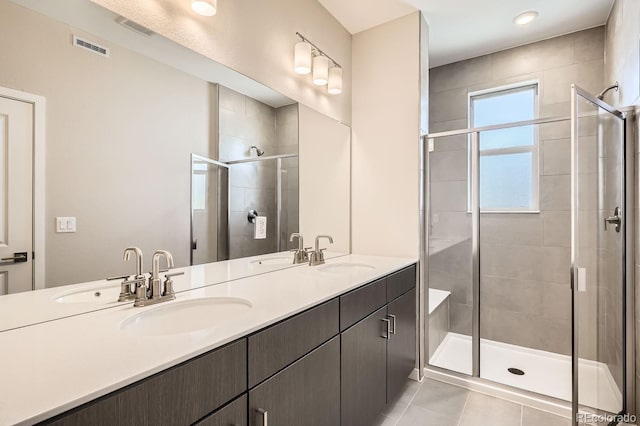 bathroom with visible vents, a sink, and a shower stall