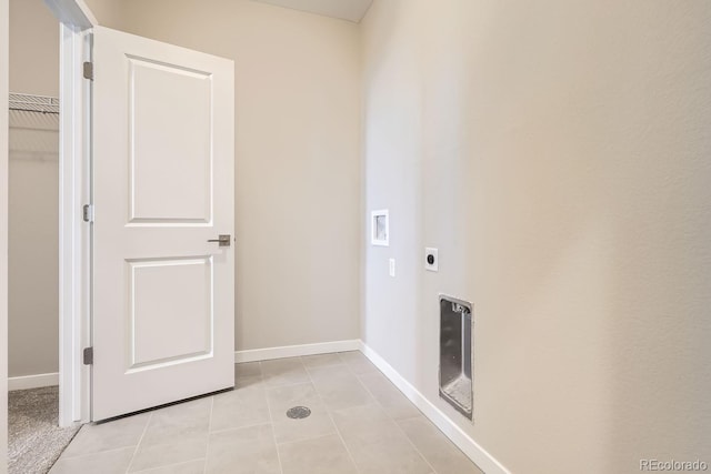 clothes washing area with light tile patterned floors, hookup for a washing machine, hookup for an electric dryer, laundry area, and baseboards