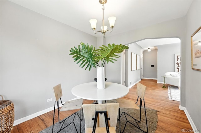 2955 Poplar St, Denver, CO 80207 - dining space with light wood finished floors, arched walkways, and a chandelier