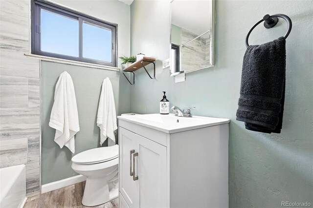 2955 Poplar St, Denver, CO 80207 - bathroom featuring vanity, wood finished floors, a tub to relax in, and a shower