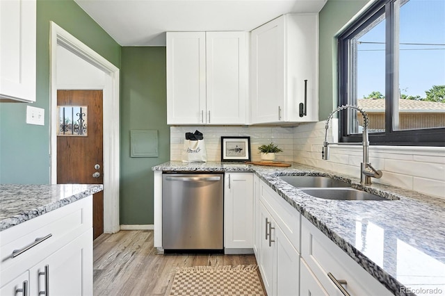 2955 Poplar St, Denver, CO 80207 - kitchen with stainless steel dishwasher, decorative backsplash, white cabinets, and light wood finished floors