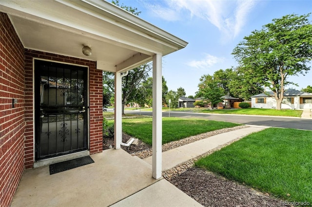 2955 Poplar St, Denver, CO 80207 - entrance to property featuring brick siding, a yard, and covered porch