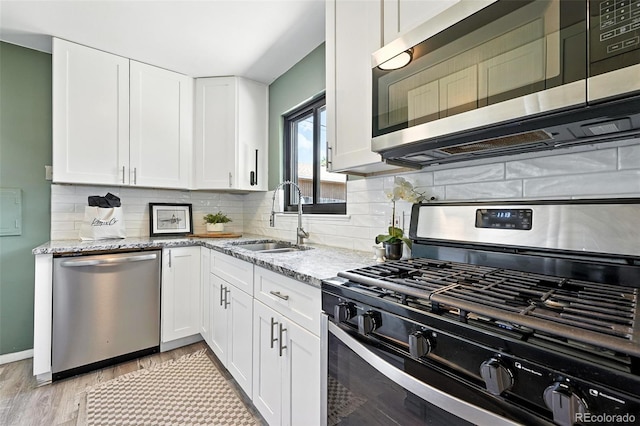 2955 Poplar St, Denver, CO 80207 - kitchen featuring appliances with stainless steel finishes, light stone counters, white cabinetry, and tasteful backsplash