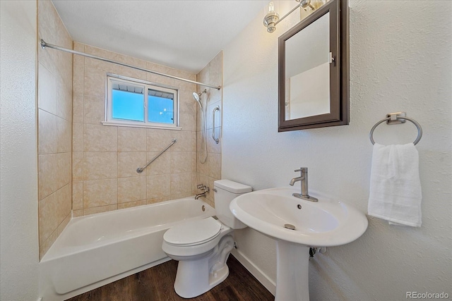 bathroom with toilet, tiled shower / bath, and hardwood / wood-style flooring