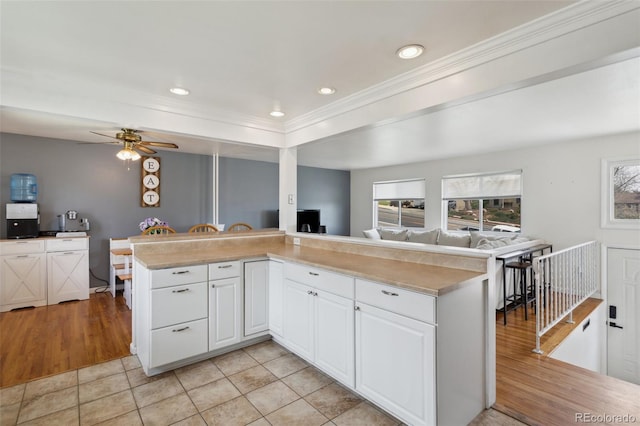 1422 N Chelton Rd, Colorado Springs, CO 80909 - kitchen with open floor plan, white cabinetry, a ceiling fan, ornamental molding, and light countertops