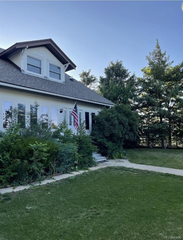 415 N Division Ave, Sterling, CO 80751 - view of front of house with a front lawn and a shingled roof