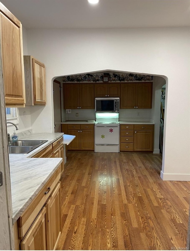 415 N Division Ave, Sterling, CO 80751 - kitchen featuring electric range, arched walkways, light countertops, and wood finished floors