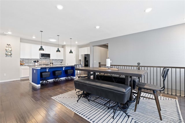 dining room featuring baseboards, dark wood-type flooring, and recessed lighting