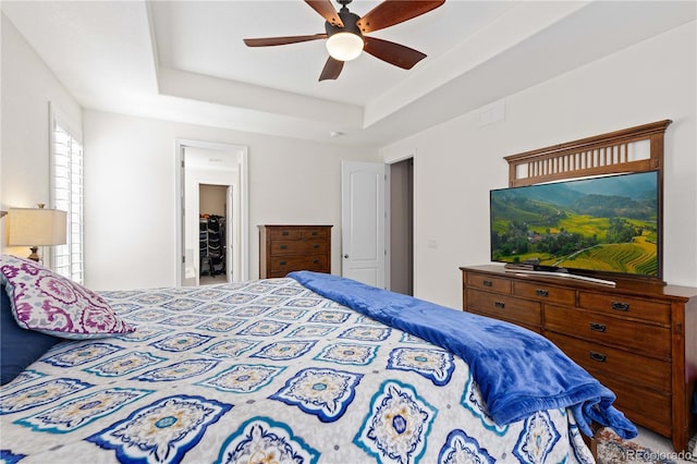 bedroom featuring a raised ceiling and ceiling fan