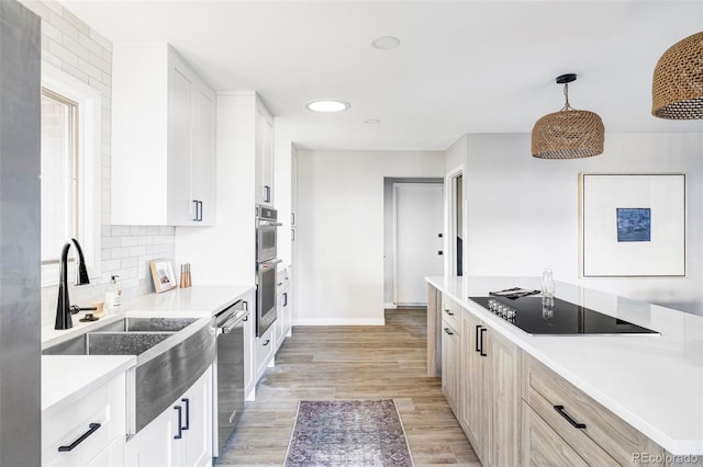 kitchen featuring white cabinets, pendant lighting, stainless steel appliances, and sink