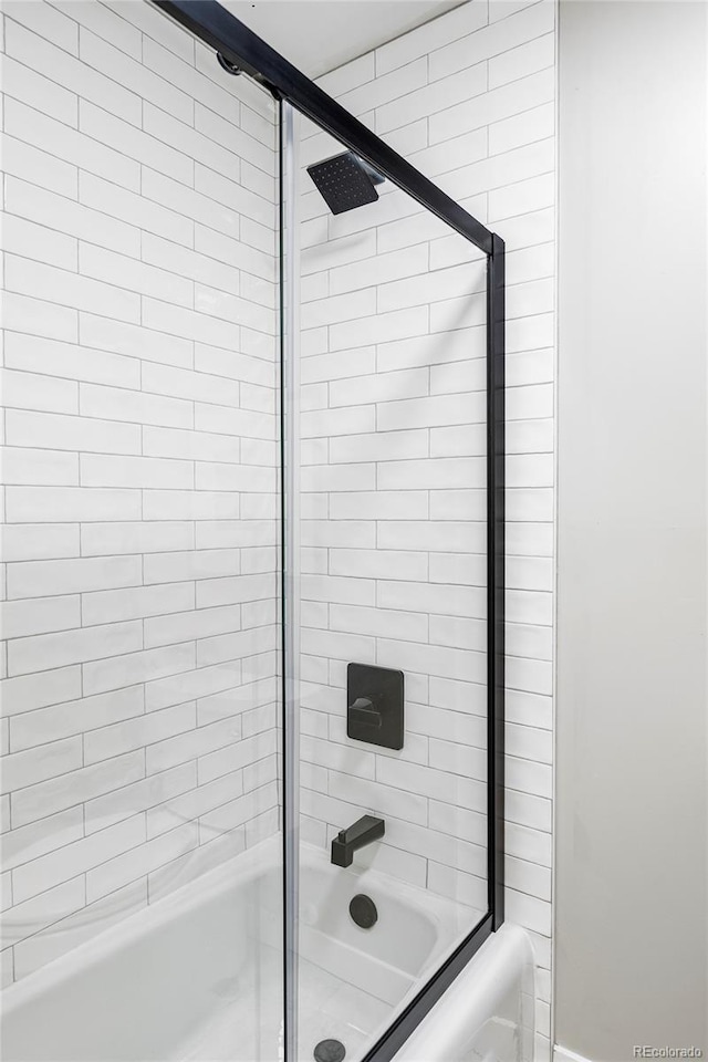 bathroom with shower / bath combination with glass door