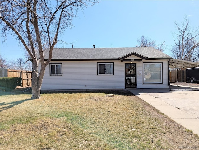 single story home with a shingled roof, a front yard, and fence