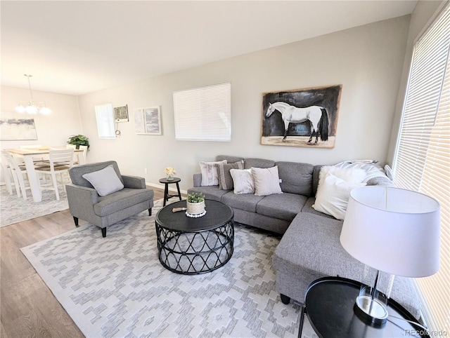 living area featuring wood finished floors, baseboards, and a chandelier