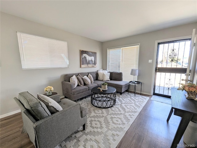 living area with baseboards and wood finished floors