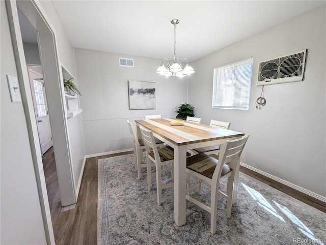 dining space featuring visible vents, baseboards, an inviting chandelier, and wood finished floors