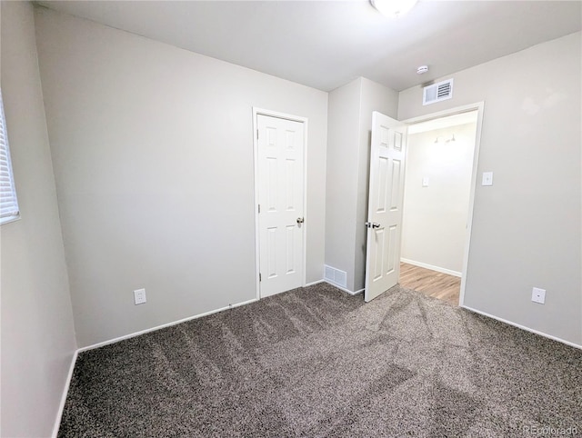 unfurnished bedroom featuring visible vents, baseboards, and carpet flooring