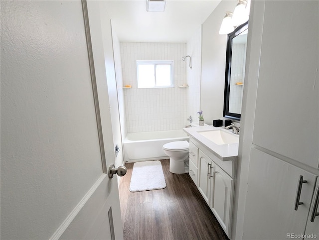 bathroom with toilet, shower / washtub combination, wood finished floors, and vanity