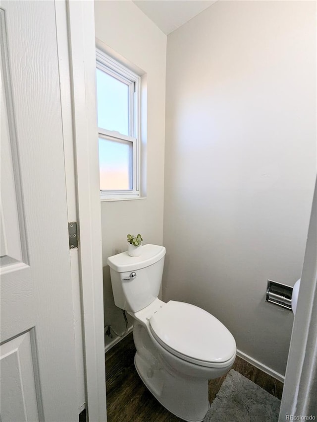 bathroom featuring toilet, baseboards, and wood finished floors