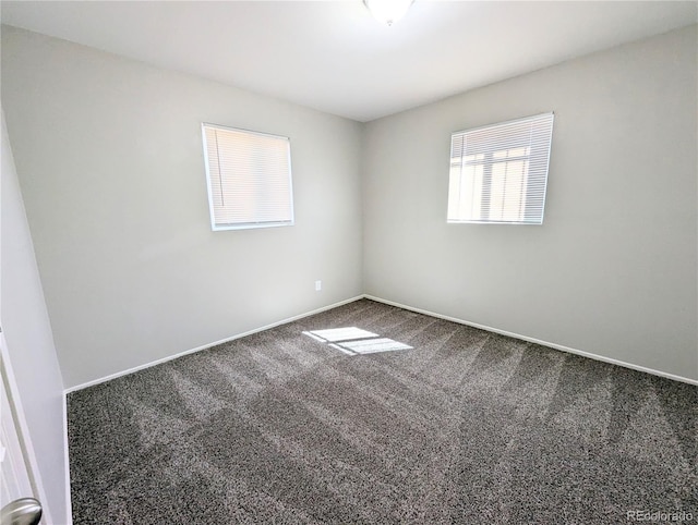 unfurnished room featuring baseboards and carpet