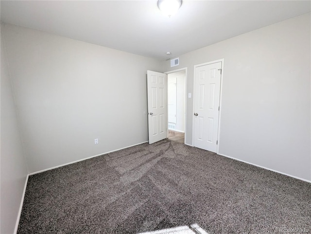 unfurnished bedroom with carpet flooring, baseboards, and visible vents