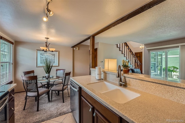 2090 S Hannibal Way Unit F, Aurora, CO 80013 - kitchen with a textured ceiling, light colored carpet, appliances with stainless steel finishes, a sink, and a notable chandelier