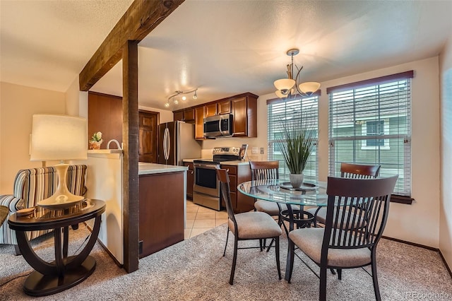 2090 S Hannibal Way Unit F, Aurora, CO 80013 - dining space with baseboards, an inviting chandelier, light tile patterned floors, and light colored carpet