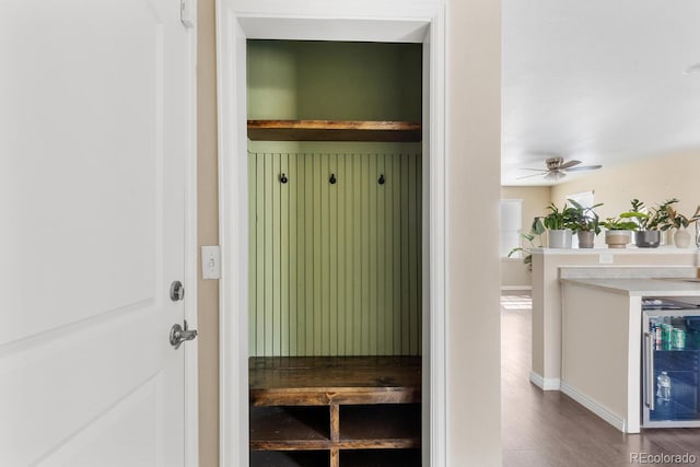 mudroom with a ceiling fan, wine cooler, baseboards, and wood finished floors