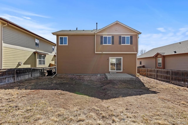 rear view of property featuring a patio area and a fenced backyard