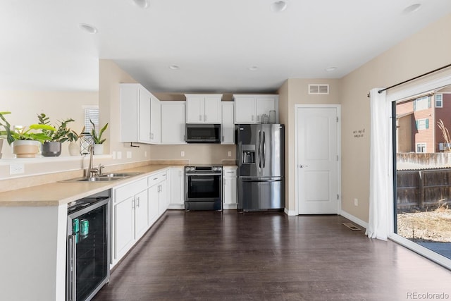 kitchen featuring a wealth of natural light, stainless steel appliances, wine cooler, and visible vents