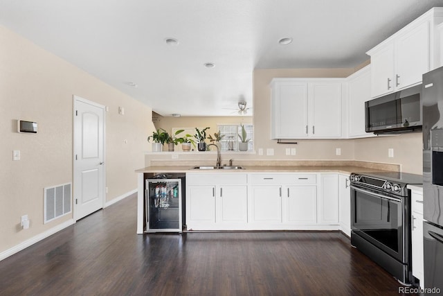 kitchen featuring black microwave, wine cooler, a sink, visible vents, and electric stove