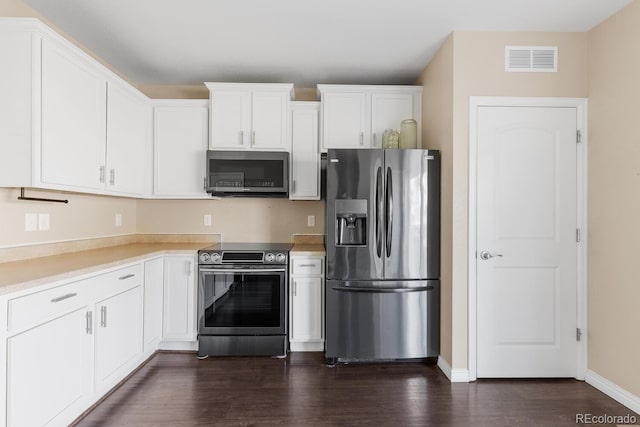 kitchen with stainless steel appliances, dark wood-style flooring, visible vents, and white cabinets