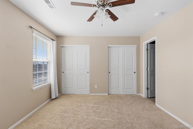 unfurnished bedroom featuring ceiling fan, visible vents, baseboards, a closet, and carpet