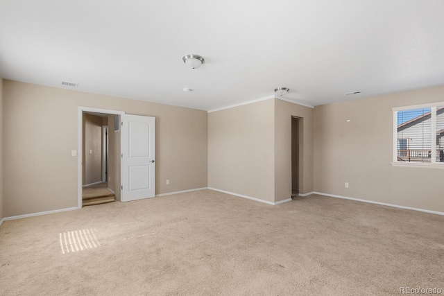 empty room featuring visible vents, light carpet, and baseboards