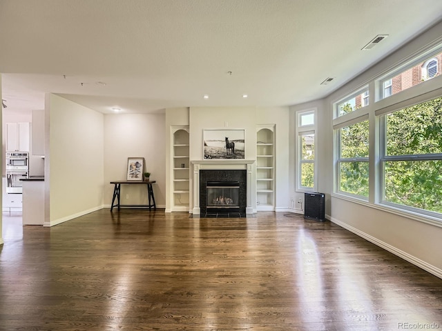 30 Garfield St Unit B, Denver, CO 80206 - unfurnished living room featuring wood finished floors, built in features, baseboards, a premium fireplace, and recessed lighting