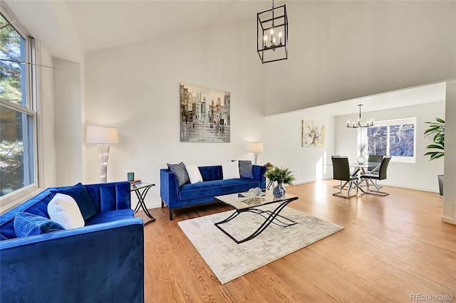 living room with a chandelier, wood-type flooring, and a high ceiling