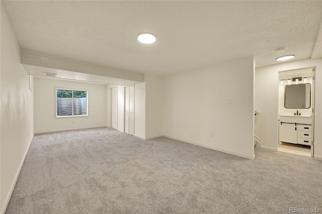 carpeted empty room with a textured ceiling