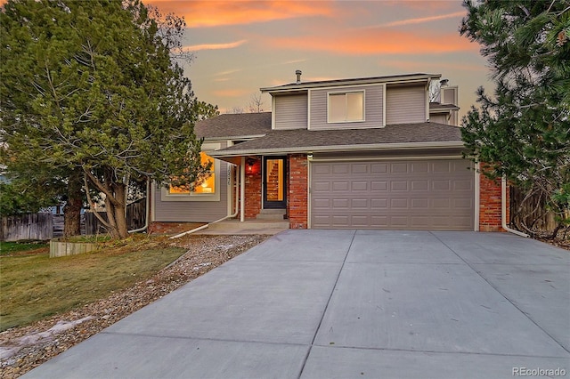 front of property with a garage and a yard