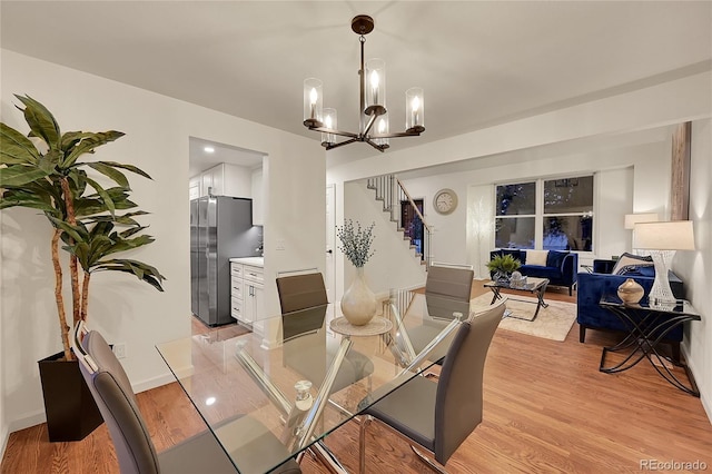 dining area featuring light hardwood / wood-style floors and a notable chandelier