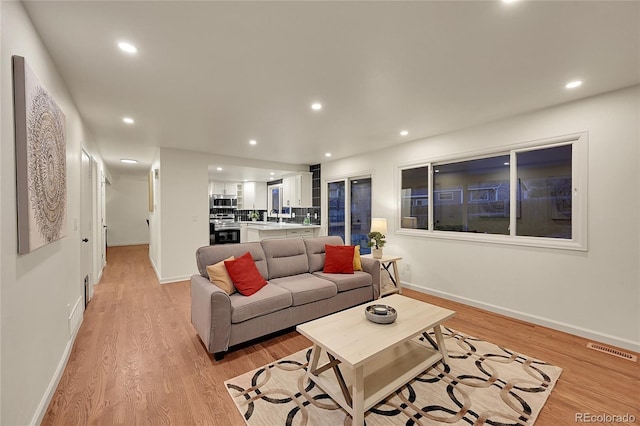 living room featuring light hardwood / wood-style floors and sink