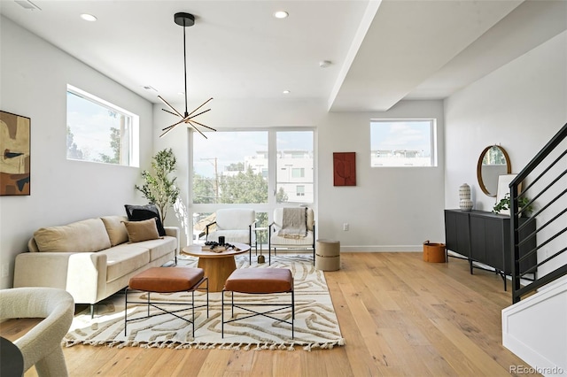 living room with an inviting chandelier and light wood-type flooring