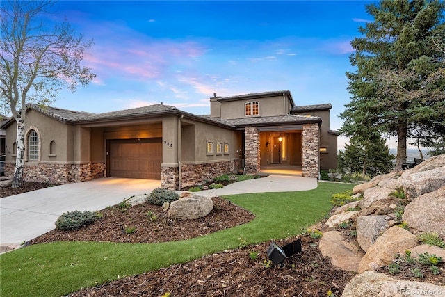 948 Manor Gate Pt, Colorado Springs, CO 80906 - prairie-style house featuring stone siding, stucco siding, a garage, and driveway