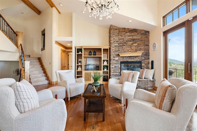 948 Manor Gate Pt, Colorado Springs, CO 80906 - living area with high vaulted ceiling, stairway, wood finished floors, a chandelier, and a stone fireplace