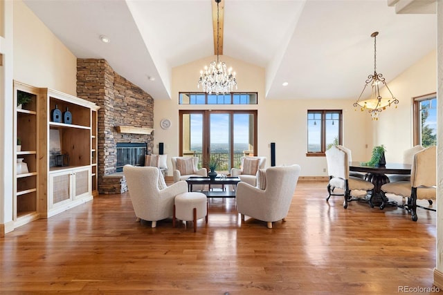 948 Manor Gate Pt, Colorado Springs, CO 80906 - living area with a chandelier, wood finished floors, a stone fireplace, beam ceiling, and high vaulted ceiling