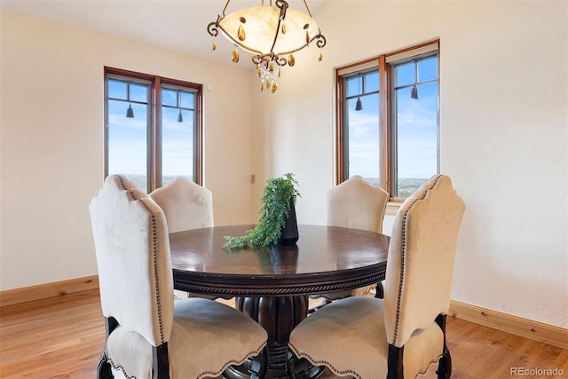 948 Manor Gate Pt, Colorado Springs, CO 80906 - dining area with baseboards, light wood finished floors, and a chandelier