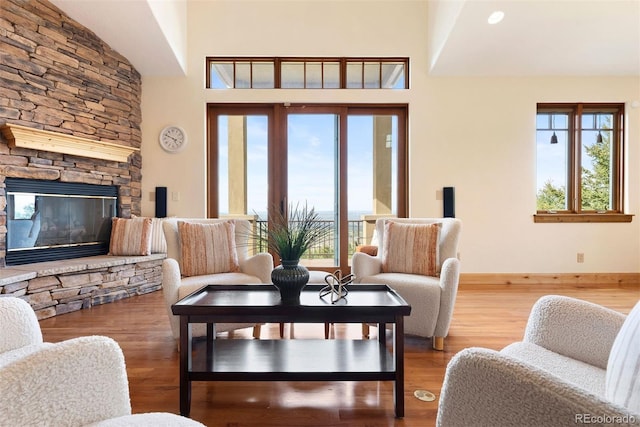948 Manor Gate Pt, Colorado Springs, CO 80906 - living room with plenty of natural light, wood finished floors, baseboards, a fireplace, and a high ceiling