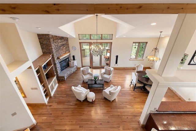 948 Manor Gate Pt, Colorado Springs, CO 80906 - living area with a chandelier, wood finished floors, a stone fireplace, and a high ceiling