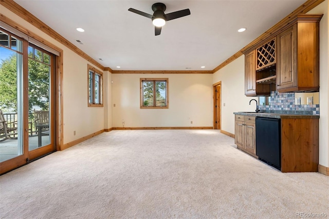 948 Manor Gate Pt, Colorado Springs, CO 80906 - kitchen with dishwasher, light carpet, baseboards, crown molding, and dark countertops