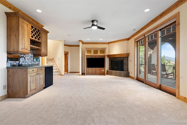 948 Manor Gate Pt, Colorado Springs, CO 80906 - unfurnished living room featuring baseboards, a sink, ornamental molding, light colored carpet, and recessed lighting