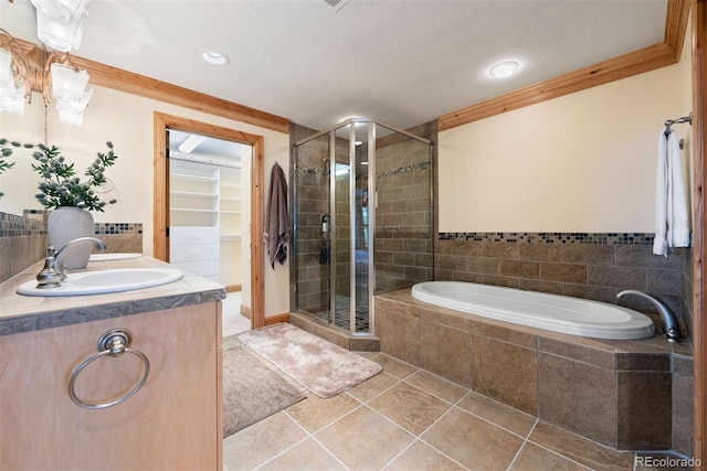 948 Manor Gate Pt, Colorado Springs, CO 80906 - bathroom featuring a shower stall, tile patterned flooring, a bath, vanity, and a walk in closet