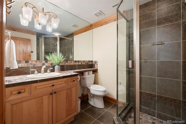 948 Manor Gate Pt, Colorado Springs, CO 80906 - bathroom with a shower stall, toilet, decorative backsplash, tile patterned flooring, and vanity